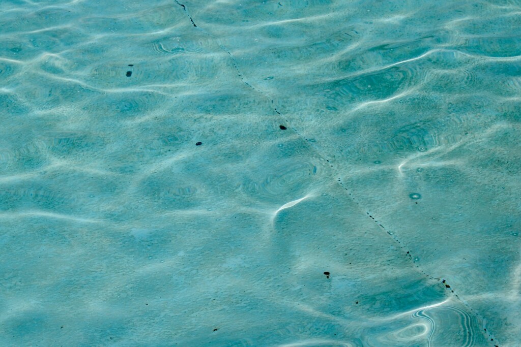 Clear blue water with shimmering sunlight.